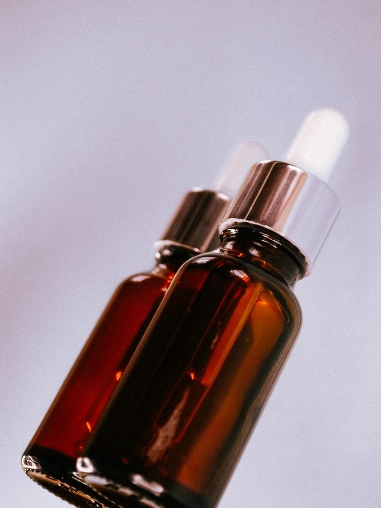 Skincare bottles and stone mortar on travertine.