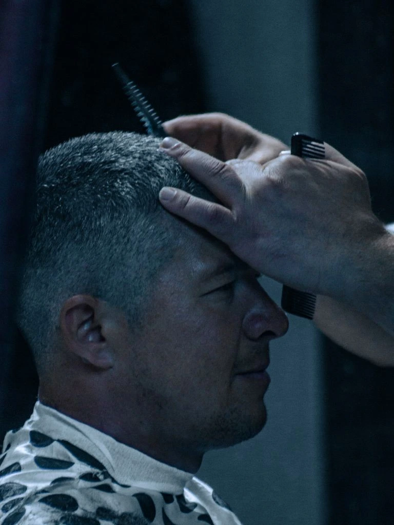 Master barber consulting a client in a leather chair