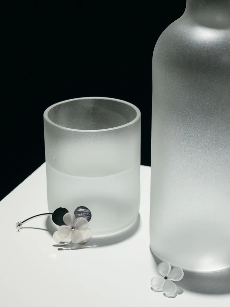 Frosted glass cologne bottle on walnut